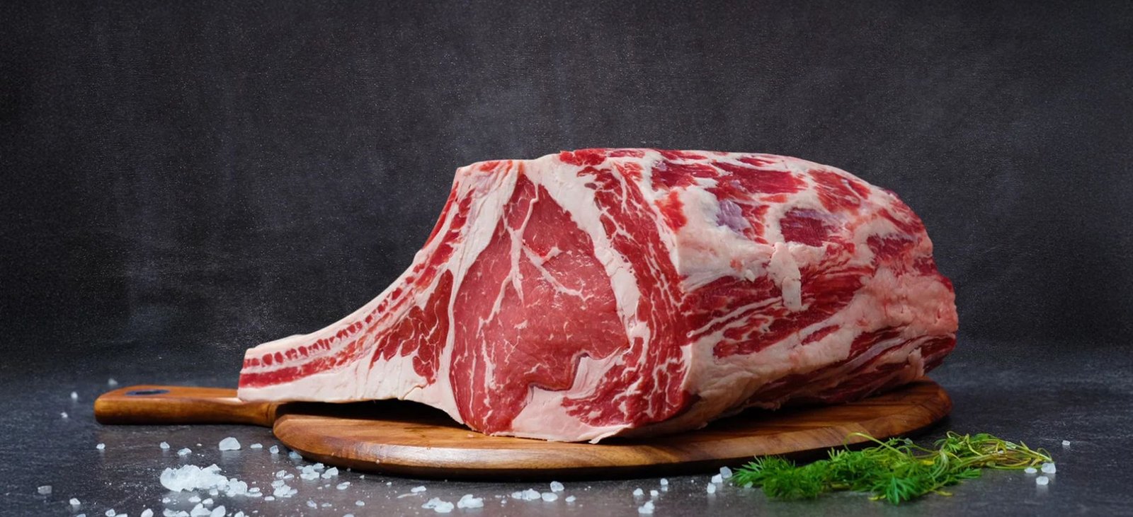 Premium raw ribeye beef cuts arranged on a wooden board, the kind of quality meat delivered in an organic meat box